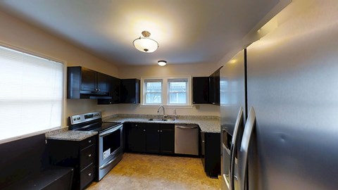 A kitchen with black appliances and cabinets.