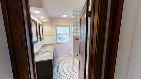 A bathroom with a sink, mirror, and tiled floor.