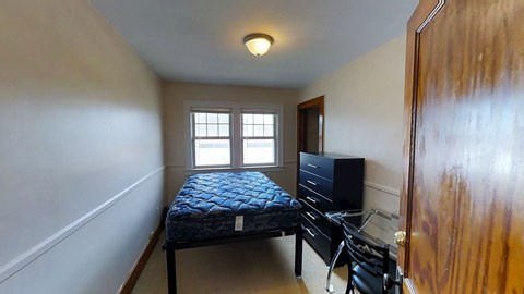 A bedroom with a bed, dresser, and television.