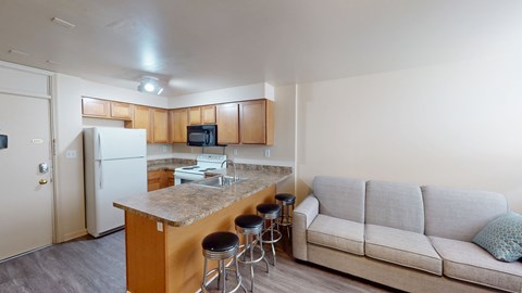A kitchen with a bar and a couch.