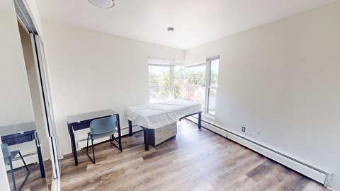A bedroom with a bed, desk, and chair.