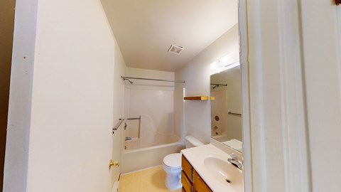 A white bathroom with a sink, toilet and bathtub.