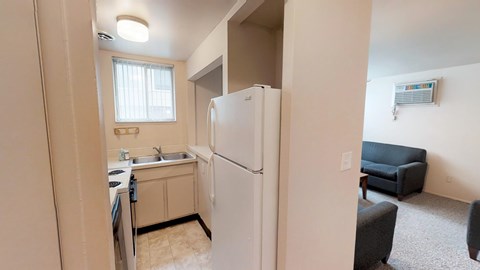 A kitchen area with a refrigerator, sink, and microwave.