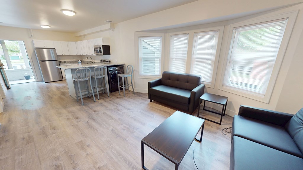 A kitchen with a refrigerator, microwave, and oven.