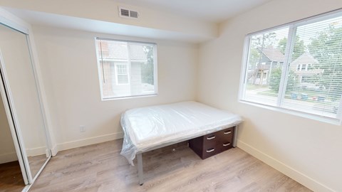A bedroom with a bed, nightstand, and window.