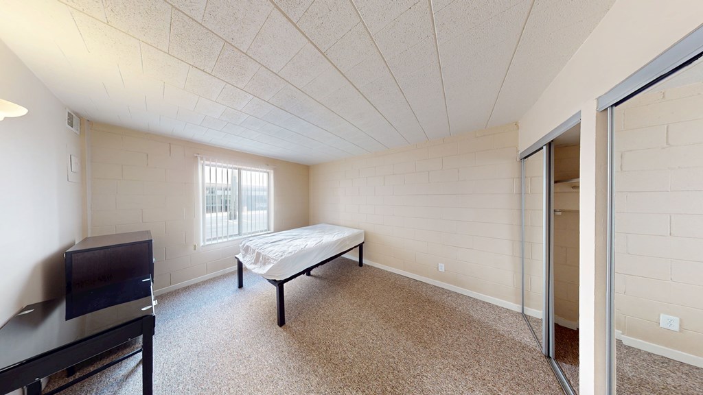 A bedroom with a bed, dresser, and television.