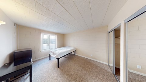 A bedroom with a bed, dresser, and television.