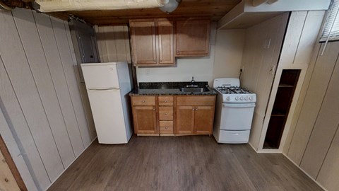 A kitchen with wooden cabinets and a white fridge.