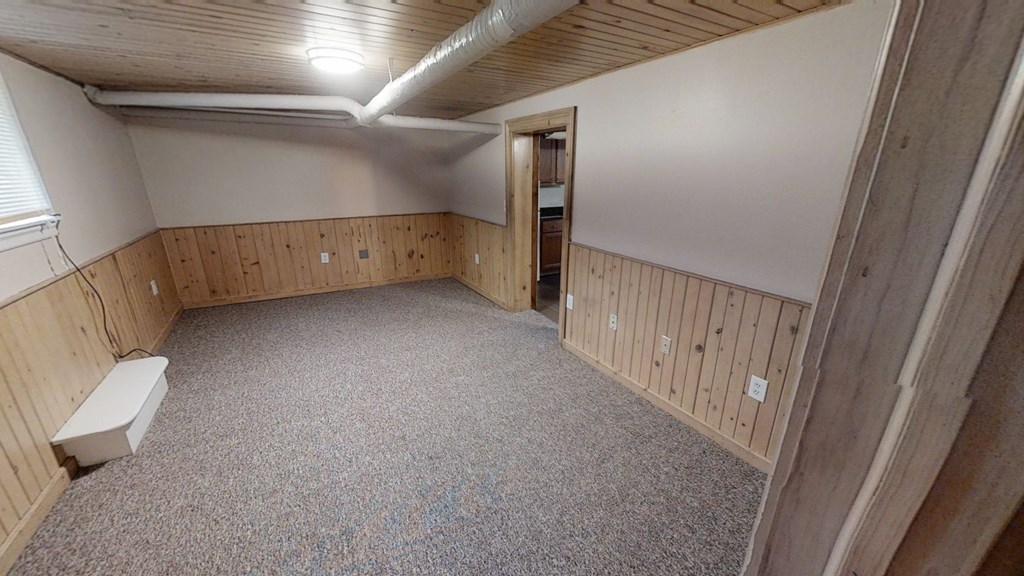 A room with wooden walls and a carpeted floor.