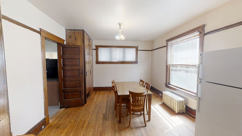 A room with a wooden floor and a table with chairs.