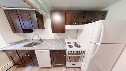 A kitchen with white appliances and brown cabinets.