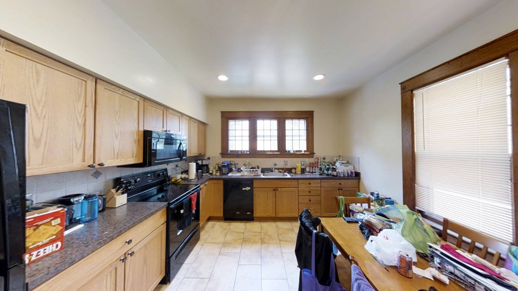 A kitchen with wooden cabinets and black appliances.