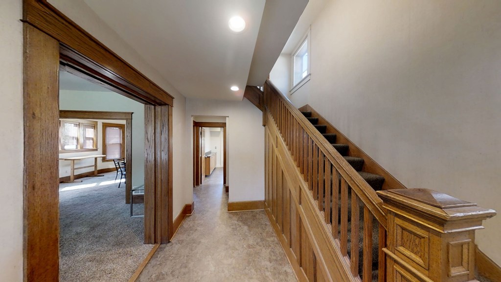 A long hallway with a staircase on the right side.