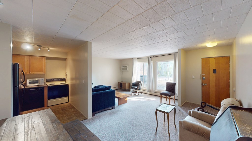 A living room with a couch, chairs, and a dining table.