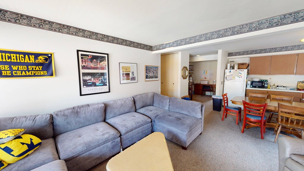 A living room with a grey couch and a yellow pillow.
