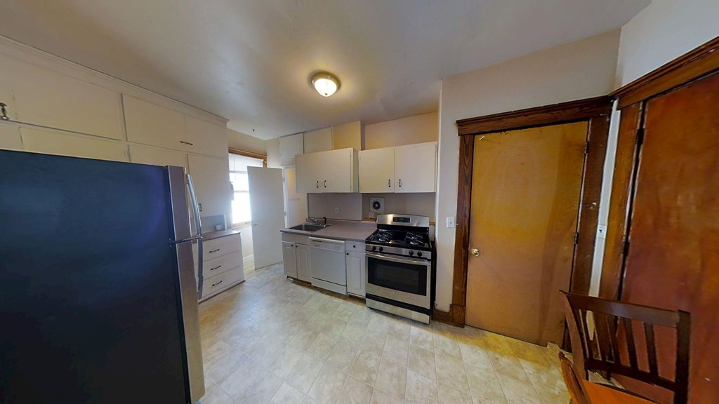 A kitchen with a refrigerator, oven, and stove.