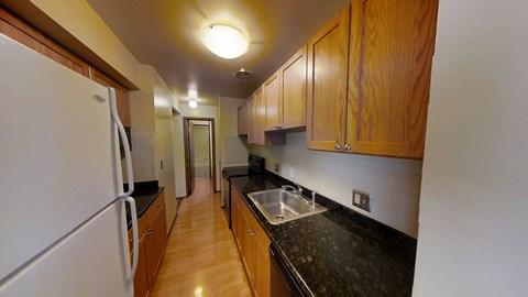 A kitchen with wooden cabinets and a white refrigerator.