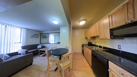 A kitchen with a black counter top and wooden cabinets.