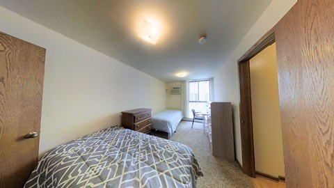 A bedroom with a bed, dresser, and mirror.
