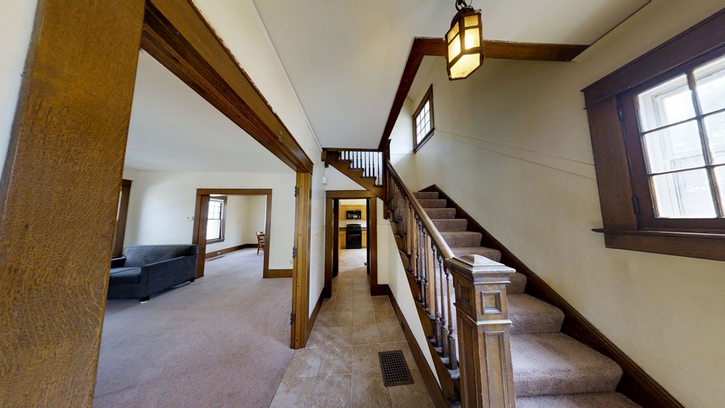 A long hallway with a staircase and a window.
