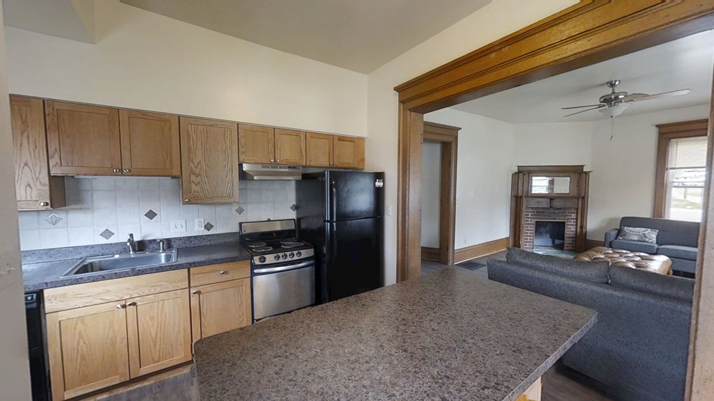 A kitchen with wooden cabinets and black appliances.