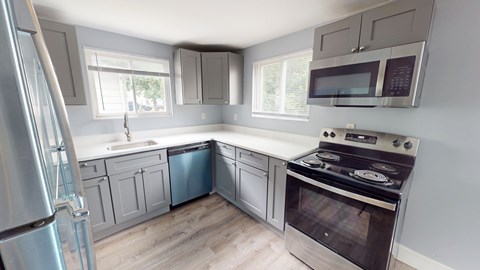 A kitchen with a stove, refrigerator, and cabinets.