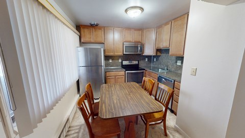 A kitchen with a table and chairs.