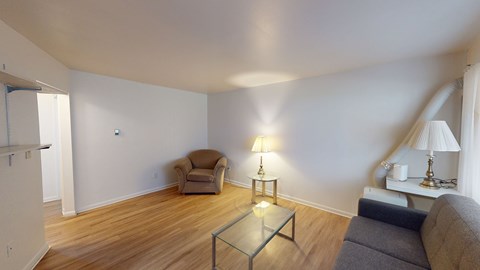 A living room with a grey couch, a chair, and a coffee table.