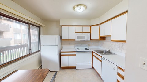 A kitchen with white appliances and wooden cabinets.