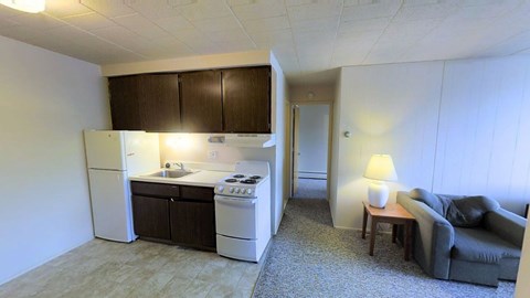 A small kitchen with a refrigerator, oven, and sink.