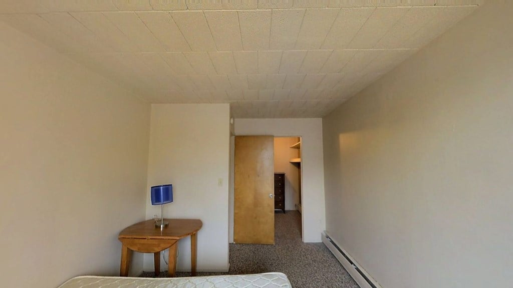 A room with a table and a bed.