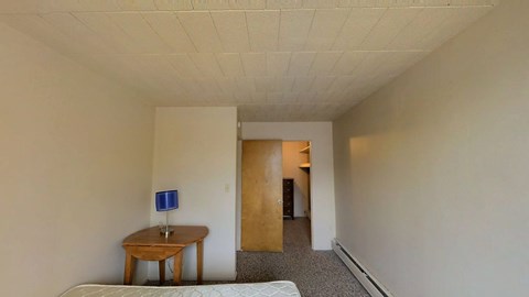 A room with a table and a bed.