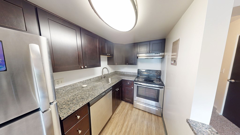 A kitchen with a refrigerator, oven, and microwave.
