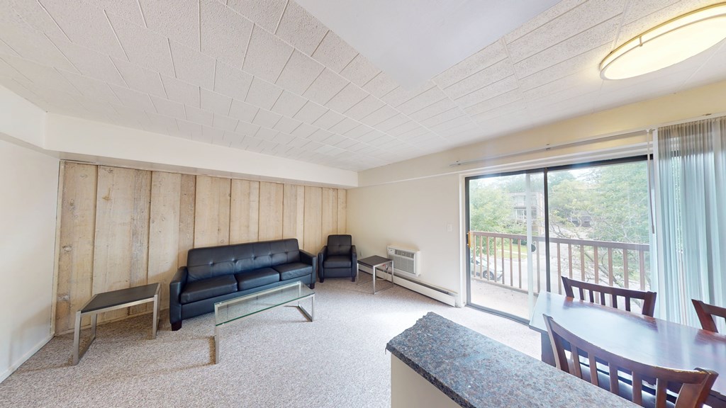 A living room with a couch, chairs, and a table.