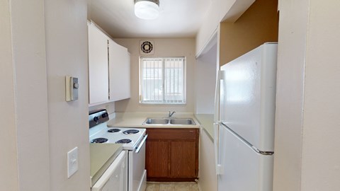 A kitchen with white appliances and wooden cabinets.