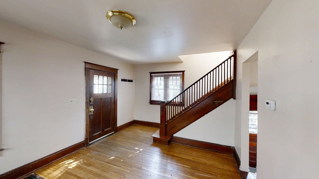 A room with a wooden floor and a staircase.