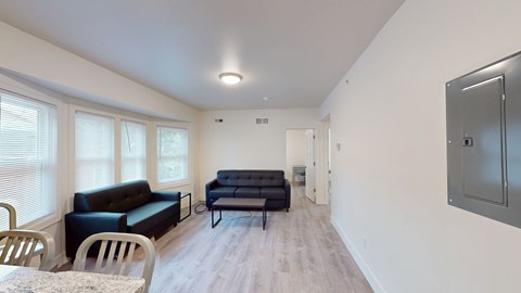 A living room with a black couch and a grey cabinet.