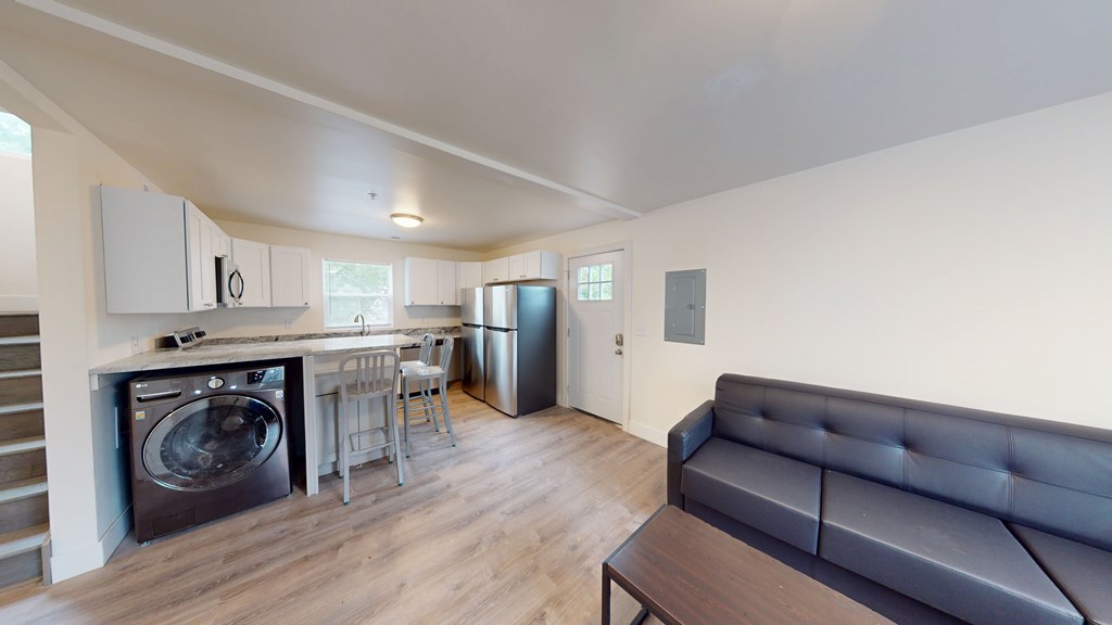 A modern kitchen with a washing machine built into the cabinetry.