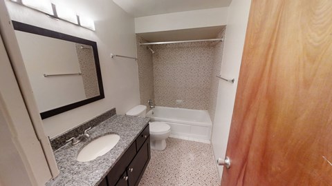 A bathroom with a sink, toilet, and shower.