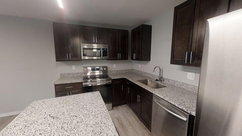 A kitchen with granite countertops and stainless steel appliances.