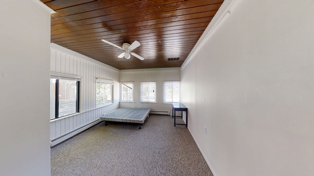 A room with a wooden ceiling and a carpeted floor.