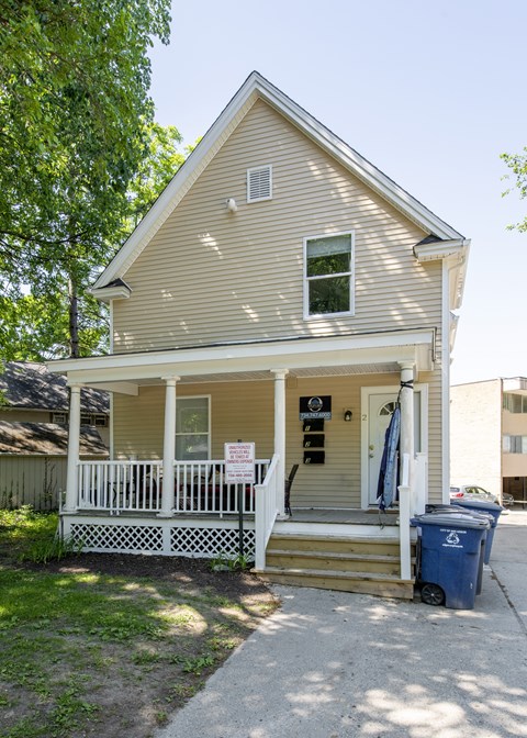A small house with a sign on the front door.