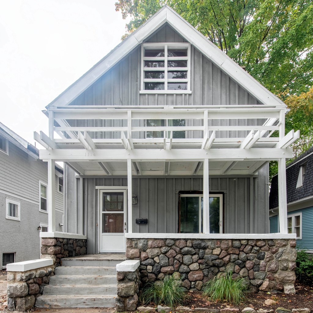 A house with a grey front and white porch.