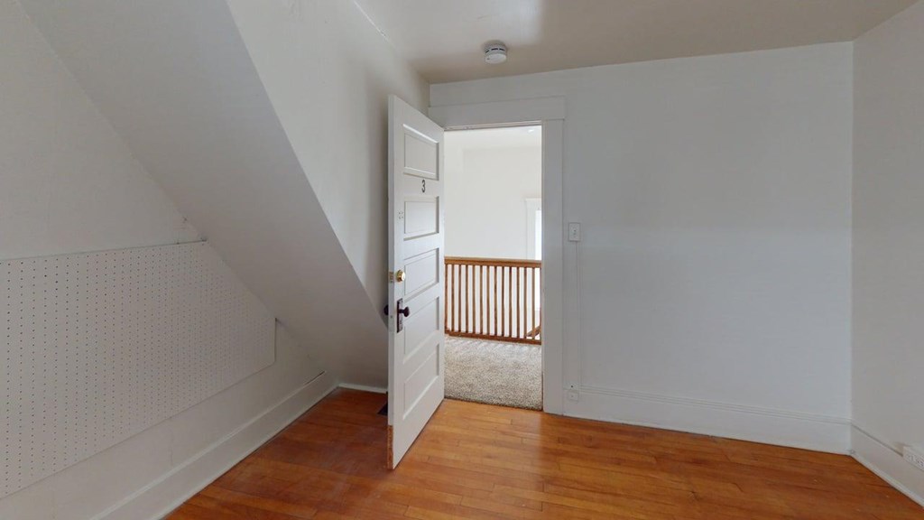 A room with a wooden floor and a white door.