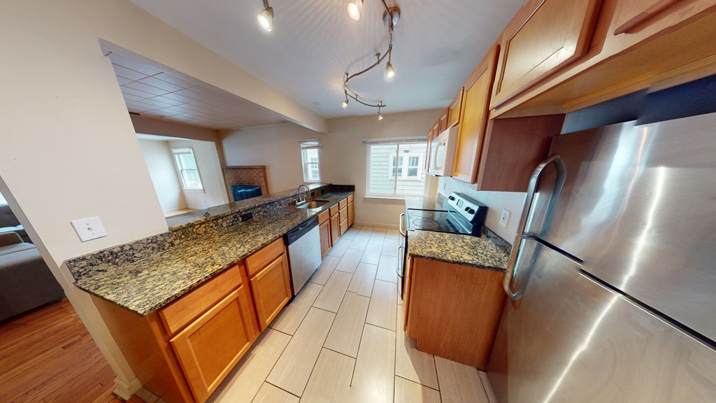A kitchen with wooden cabinets and granite countertops.