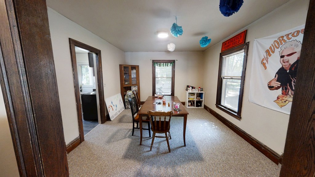 A dining room with a wooden table and chairs.