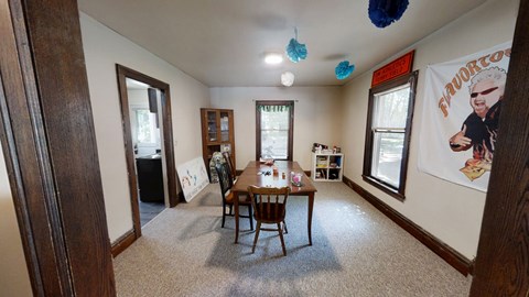 A dining room with a wooden table and chairs.