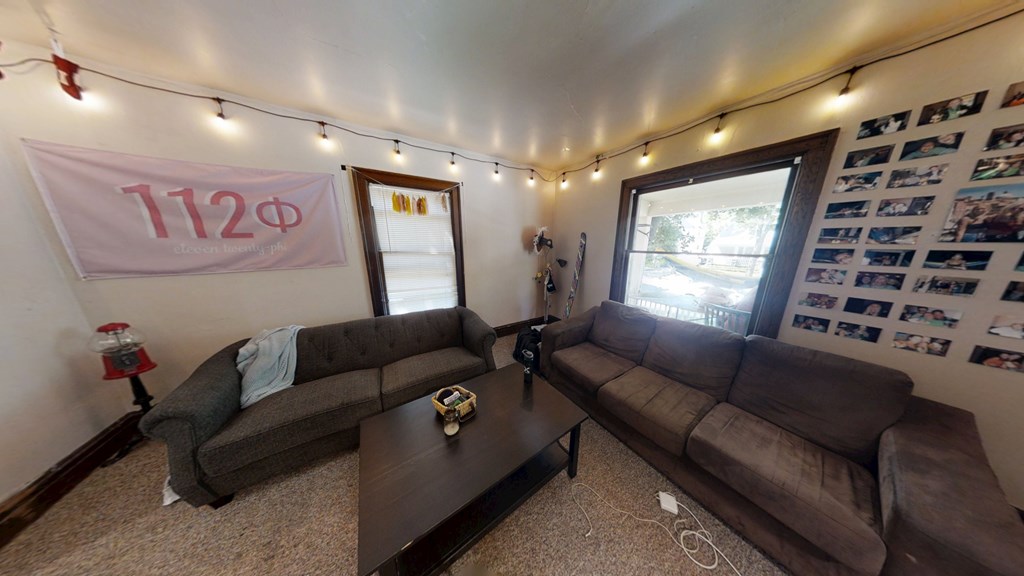 A living room with a grey couch, a brown couch, and a coffee table.