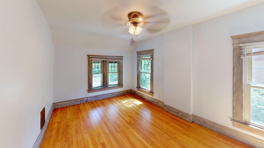 A room with wooden floors and a ceiling fan.