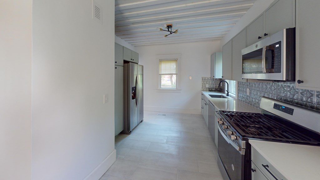 A kitchen with a stove top oven and a microwave above it.